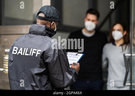 Huissier de recouvrement de dette à porte dans le masque Banque D'Images