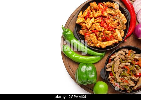 Poêles à frire avec de savoureux fajita et légumes sur fond blanc Banque D'Images