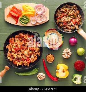 Composition avec de savoureux fajita, légumes, sauce et chapeau de sombrero sur fond de bois de couleur Banque D'Images