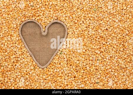 Le cœur symbolique faite de corde se trouve sur le sac et les pois, céréales avec de l'espace pour votre texte Banque D'Images