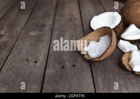 Noix de coco cassées sur fond en bois gris. Pâte de coco blanche. Photo de haute qualité Banque D'Images