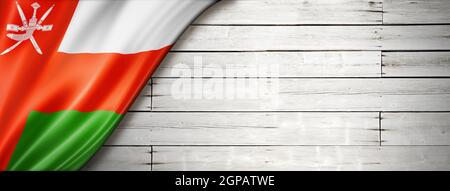 Drapeau d'Oman sur l'ancien mur blanc. Bannière panoramique horizontale. Banque D'Images