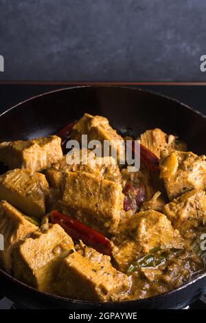 cuisine de cari aux fruits du jaquette, tempering avec de l'huile et du lait de coco, plat végétarien sri lankais classique sur une casserole, vue rapprochée Banque D'Images