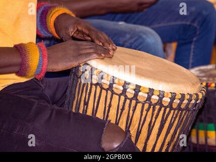 Gros plan d'un batteur africain djembe. Batteur jouant de la musique africaine à percussion. Instruments de musique à percussion ethnique Djembe et mains masculines. Rythme de Banque D'Images