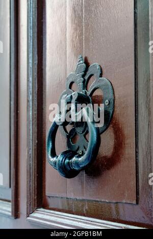 Porte en bois sombre avec un knocker noir Banque D'Images