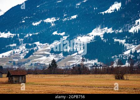 Structure d'entrepôt en bois pour stocker le foin et le bois de chauffage pour les peuplements d'hiver en premier plan dans le champ, grande montagne est visible dans le backgro Banque D'Images