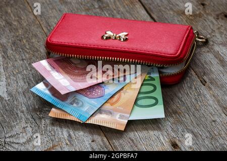 Portefeuille femme rouge plein de billets euro cash money Banque D'Images