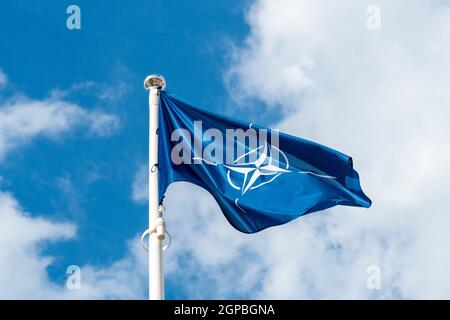 De brandir le drapeau de l'OTAN dans le vent contre le fond de ciel Banque D'Images