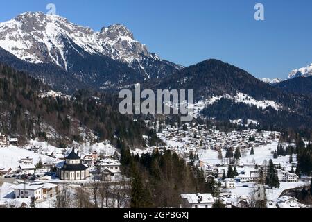 Vue blanche d'hiver du village touristique dans les Dolomites, tourné sous un ciel bleu profond Banque D'Images