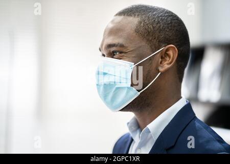 Réceptionniste Homme portant un masque médical à la réception du bureau Banque D'Images