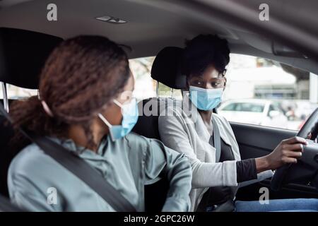 Covoiturage à l'intérieur. Partage de voiture. Amis Carpooling dans masque de visage Banque D'Images