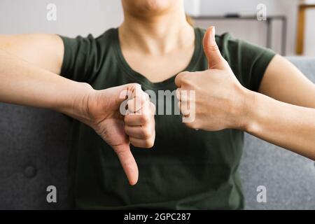 Femme indécis montrant des Thumbs vers le haut vers le bas geste Banque D'Images