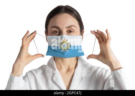 Respirateur avec drapeau de Saint-Marin le docteur met sur le masque médical isolé sur fond blanc. Banque D'Images