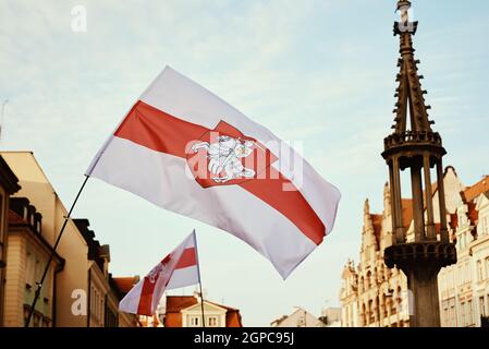 Drapeau historique national rouge blanc rouge de la Biélorussie agitant dans la rue de la ville. Banque D'Images