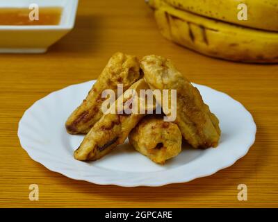 Frites de plantain mûr sur un plat blanc décoration à base de bananes et de miel Banque D'Images