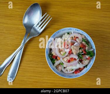 Le merlu péruvien et le ceviche de légumes, d'épices et de chaux dans un bol en céramique avec des couverts. Vue de dessus Banque D'Images