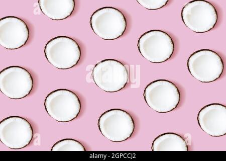Motif noix de coco sur fond rose. Ensemble de moitiés de noix de coco. Photo de haute qualité Banque D'Images