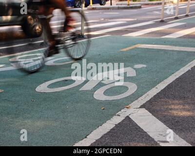 Cycliste rapide sur asphalte peint vert moto Road à Manhattan New York Banque D'Images