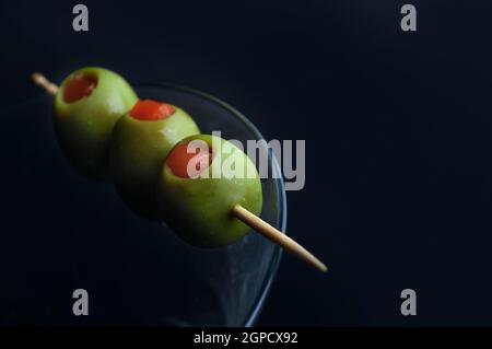 Les olives dans un verre à martini Banque D'Images