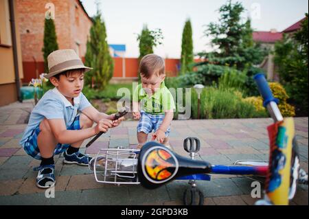 Vélo de réparation deux frères. Peu de mécaniciens travaillent avec la bicyclette. Banque D'Images