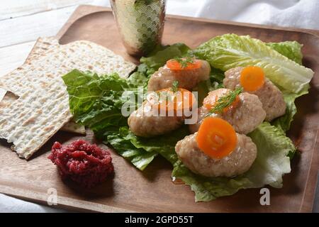 La Pâque nourriture juive traditionnelle - poisson de gefilte avec des carottes, de la laitue, du radis de cheval et du matzah. Concept de célébration de la Pâque Banque D'Images