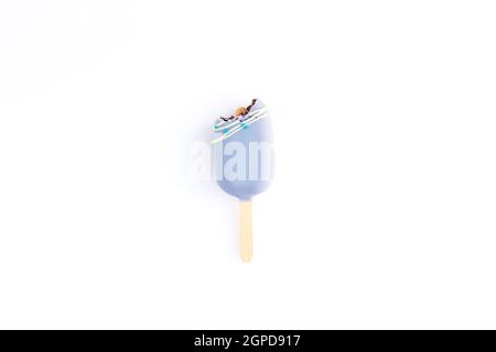 Crème glacée isolée de biscuit bleu mordu sur un bâton sur fond blanc. Couche plate avec crème glacée. Banque D'Images