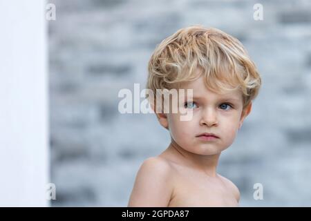 Enfant drôle sans t-shirt dans le jardin Banque D'Images