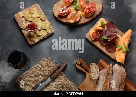Brushetta ou tapas traditionnelles espagnoles. Hors-d'œuvre avec en-cas italiens d'antipasti. Variété de petits sandwiches avec tomates cerises, saumon, crème Banque D'Images
