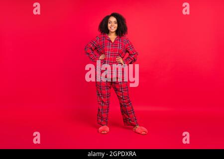 Pleine photo de joyeuse bonne afro femme américaine mains taille corps positif froid Noël isolé sur fond rouge couleur Banque D'Images