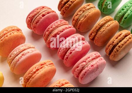 Petits gâteaux français de différentes couleurs sur fond clair Banque D'Images