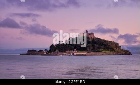 Doux ciel rose au coucher du soleil sur le mont St Michael's, une île marécageuse près de Marazion, en Cornouailles. Banque D'Images