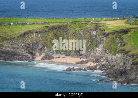 Baignade touristique dans la vue et détente sur la petite plage cachée de Coumeenoole entre les falaises de la péninsule de Dingle, Wild Atlantic Way, Kerry, Irlande Banque D'Images