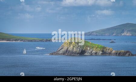 Voilier et bateau à moteur naviguant entre de petites îles rocheuses dans la péninsule de Dingle, vu de Slea Head, Wild Atlantic Way, Kerry, Irlande Banque D'Images