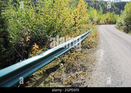 Un rail de protection sur le côté d'une route en gravier. Banque D'Images