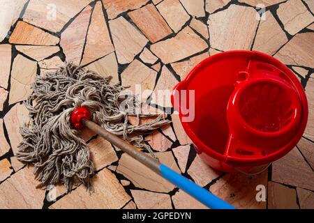 concept de nettoyage de maison, nettoyage des sols dans la maison, seau rouge et mop Banque D'Images