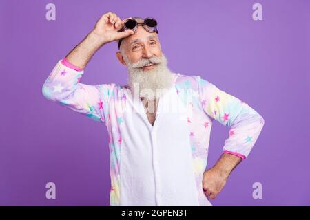 Portrait d'attrayant gai drôle homme portant pilote spécifications pyjama posant isolé sur fond violet couleur violet Banque D'Images