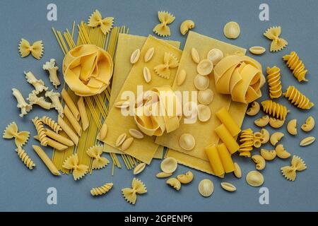 Aliments italiens Concept et design de menu. Différents types de pâtes farfalle, Pâtes Orecchiette Pugliesi, une OCIR, Gnocco Sardo et Farfalle setup sur gray Banque D'Images