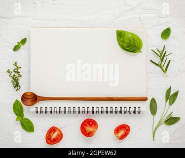 Contexte Les aliments et de l'alimentation menu design . Divers ingrédients herbes basilic, sauge, romarin, thym citron, tomates cerises tranches de configuration à l'aide d'aucun blanc Banque D'Images