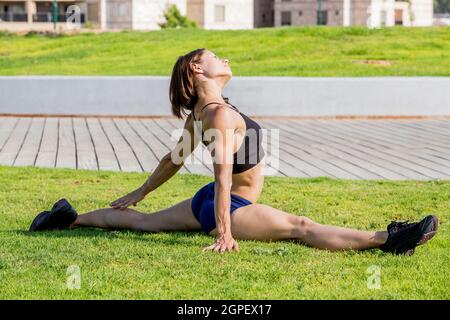 Une jeune femme fait des exercices en plein air dans un parc Banque D'Images