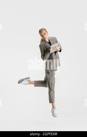 Portrait complet d'une femme, employée de bureau prenant des notes sur une tablette isolée sur fond blanc. Mouvement de ballet Banque D'Images