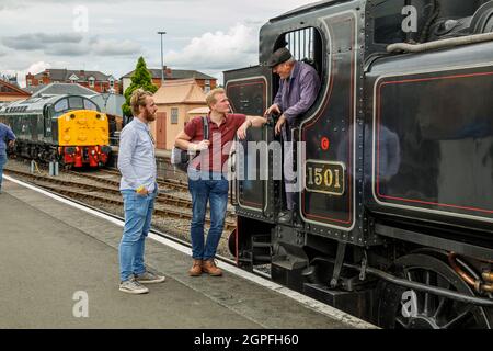 Les visiteurs discutant avec un chauffeur de moteur à la gare de Kidderminster, Severn Valley Railway, Worcestershire. Banque D'Images