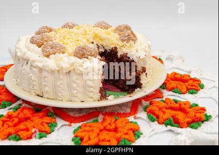 Délicieux gâteau au chocolat fourré fait maison décoré de chocolat blanc râpé et de truffes au caramel de noix de coco. Banque D'Images