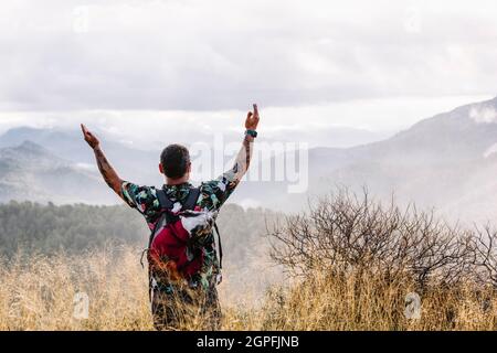 Vue arrière du voyageur avec son chien sur les bras de montagne Banque D'Images