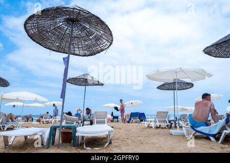 Sariyer, Istanbul, Turquie - 07.17.2021: Plage de Kilyos et zone côtière avec beaucoup de personnes s'allonger sur des chaises longues sous des parasols en paille en été Banque D'Images