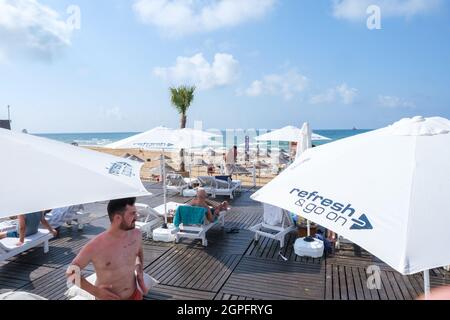 Sariyer, Istanbul, Turquie - 07.17.2021: Les Turcs de la plage de Kilyos et de la zone côtière s'allonger sur des chaises longues sous des parasols en paille en été tim Banque D'Images