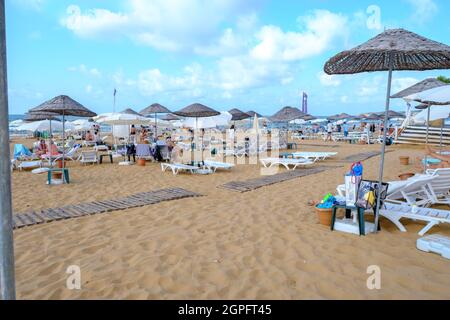 Sariyer, Istanbul, Turquie - 07.17.2021: Vue grand angle de la plage de Kilyos avec quelques personnes s'allonger sur des chaises longues sous des parasols en paille en été Banque D'Images