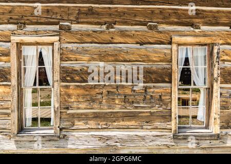 Vieilles fenêtres en bois avec un rideau dans une cabane rustique en bois Banque D'Images