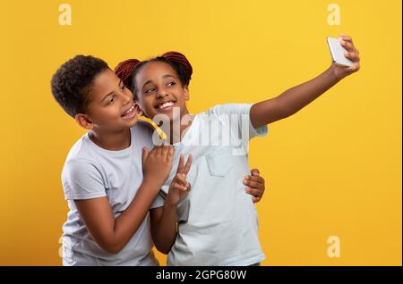 De jolis frères et sœurs afro-américains qui prennent le selfie ensemble sur un téléphone portable Banque D'Images