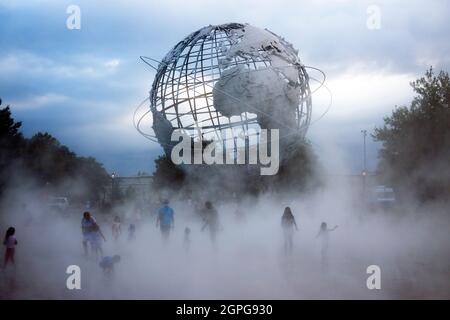 Familles jouant dans le brouillard à l'Unisphere à Flushing Meadows Corona Park Queens NYC Banque D'Images