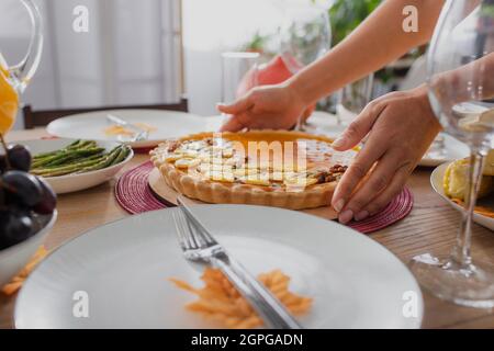 Vue rognée d'une femme afro-américaine mettant une tarte savoureuse sur une table près d'un dîner d'action de grâce Banque D'Images